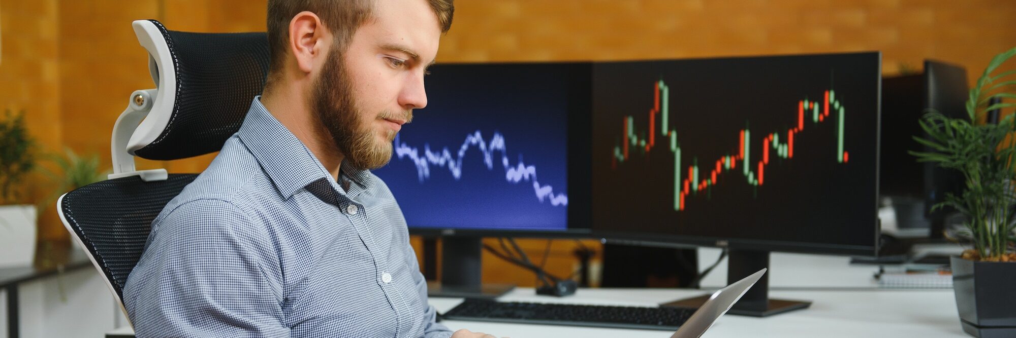 Male stockbroker in the office with financial market.